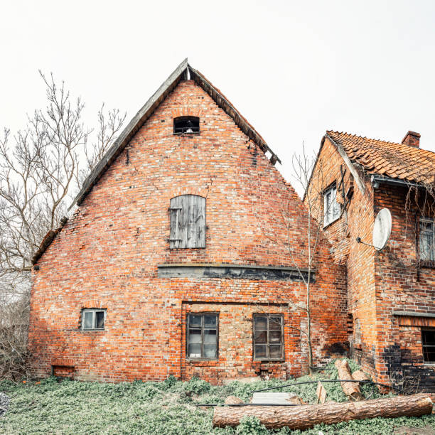 Facade of old German brick house with burnt wall in poor condition, frontal view