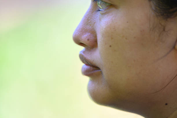 Girl portrait 11-12 years old.Close-up side view looking at camera.Background is black.Space for text