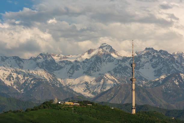 a famosa torre de tv na montanha kok-tobe, na cidade de almaty, no fundo da cordilheira zailiyskiy alatau. - alatau - fotografias e filmes do acervo