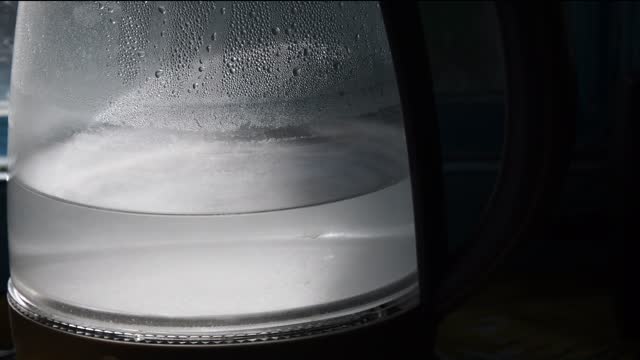 Sun flares inside transparent kettle with waving water