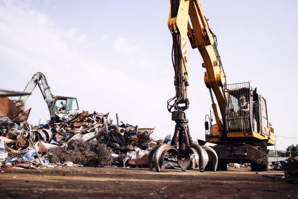 istock Man worker operating scrap metal recycling machine in junk yard. 1334041321