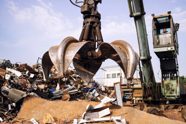 istock Crane with claw attachment lifting scrap metal in the junk yard. 1334041354