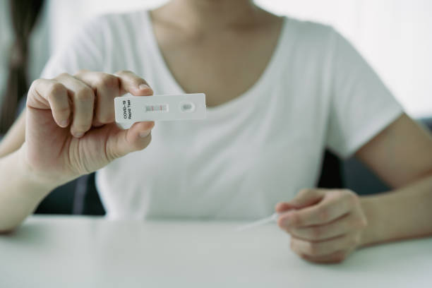 istock Woman using COVID-19 ag test kit. 1334045802