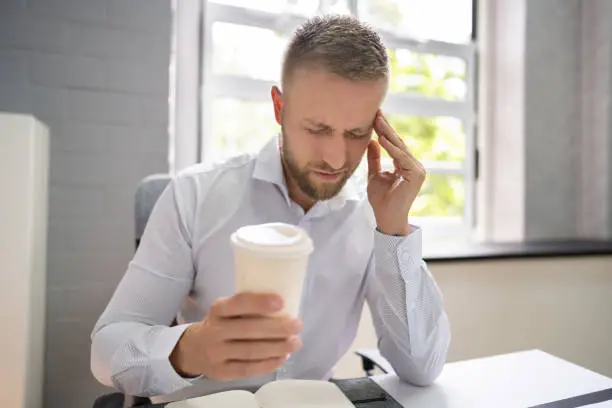 Person Holding Coffee Cup Having Headache And Migraine