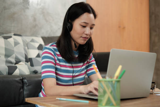 istock Asian woman using laptop for work from home and online learning. 1334054895