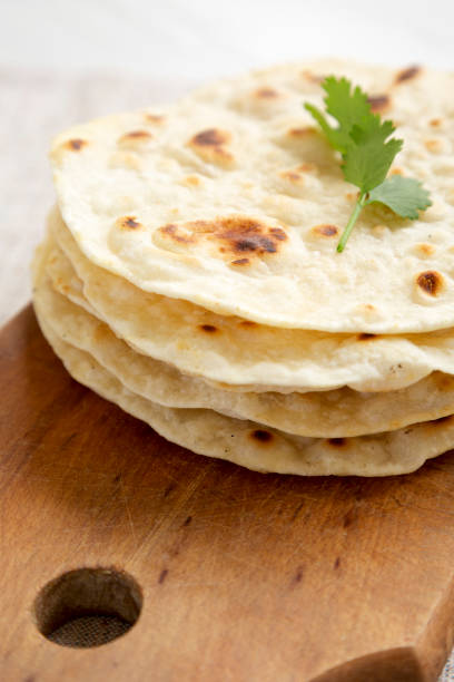 istock Homemade Roti Chapati Flatbread on a rustic wooden board, side view. Close-up. 1334060758