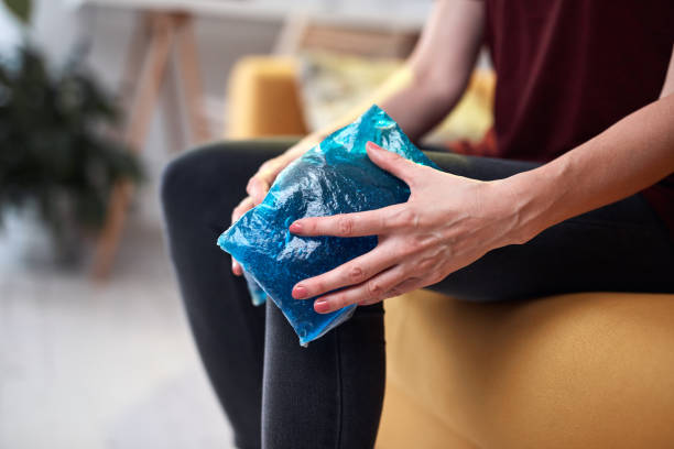 femme avec une blessure de douleur au genou à la maison en utilisant le pack de gel de glace. - ice women ice pack physical injury photos et images de collection