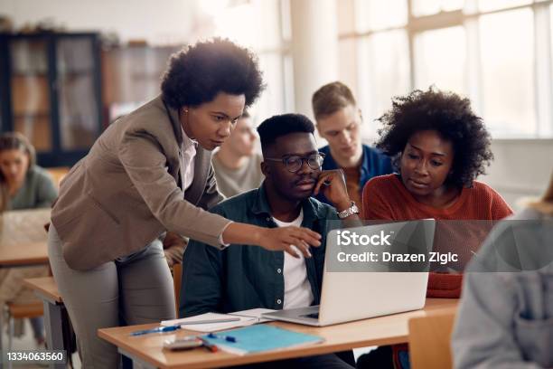 African Americans College Students Eleaning With Their Teacher During A Class Stock Photo - Download Image Now