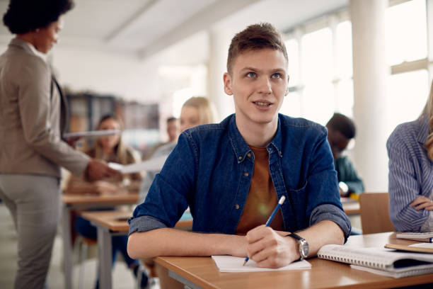 istock Young male student writing an exam in the classroom at the university. 1334063802