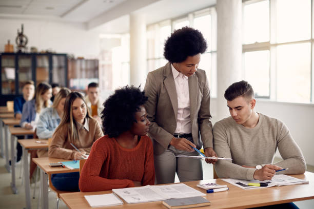 istock African American professor assisting her students on a class at the university. 1334064456