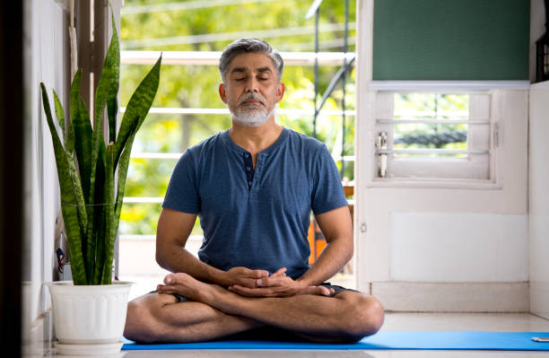 istock Man meditating in lotus position at home 1334070093