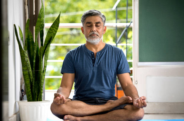 istock Man meditating in lotus position at home 1334070783