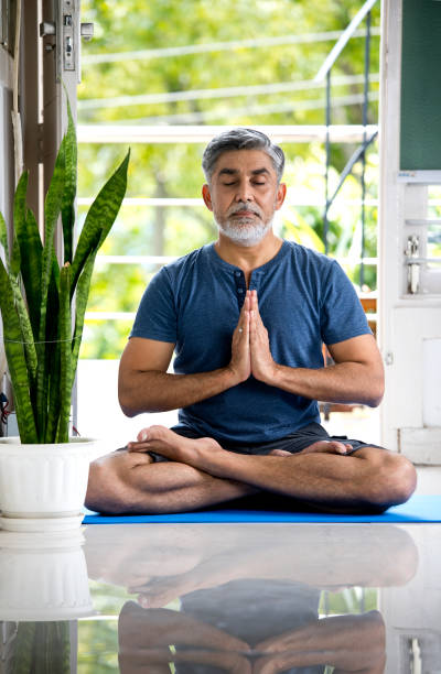 istock Man meditating on exercise mat at home 1334071175