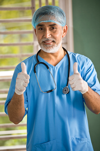 Retrato de cirujano masculino dando pulgares hacia arriba photo