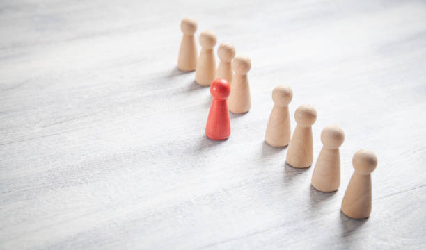 istock Wooden human figures on the white desk. Leader 1334078912