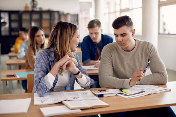 istock College friends talking while studying together during a class in the classroom. 1334083571