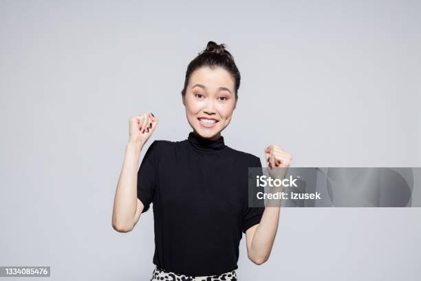 Excited Asian Young Woman Stock Photo - Download Image Now - Fist, Women, Only Women