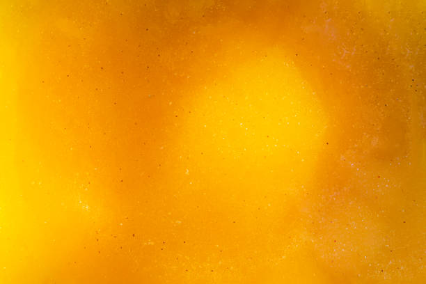 la texture de la surface du liquide doré avec des bulles dans l’air du miel d’abeille. alimentation saine. - honey abstract photography composition photos et images de collection