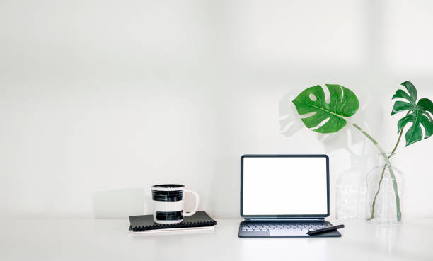 istock Blank screen tablet with keyboard on the table in white room background. 1334087020