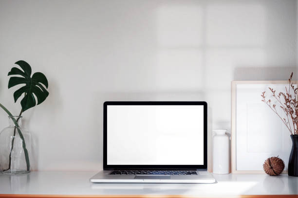 istock Mockup creative workspace with blank screen laptop computer and supplies on wooden table. 1334087709