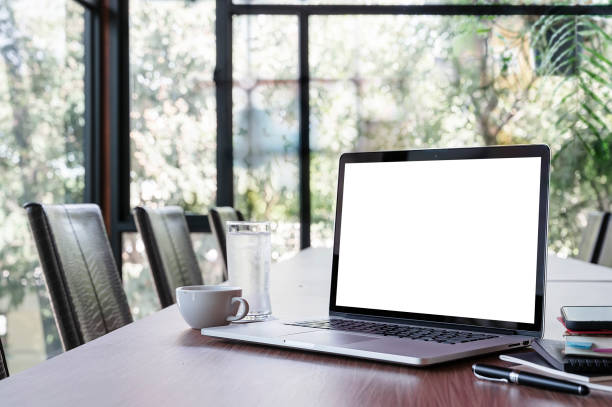 istock Mockup blank screen laptop computer on wooden table in meeting room. 1334087879