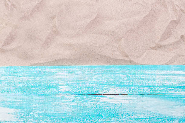istock Wooden board on the sand top view free space 1334089184