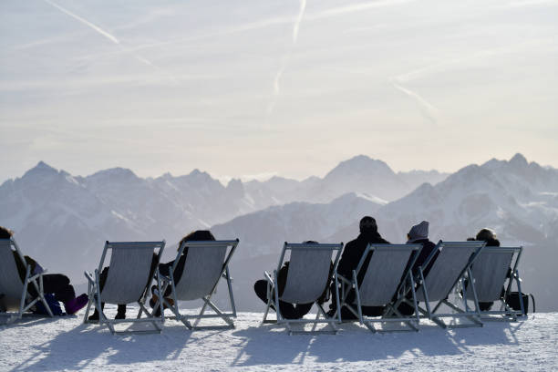 grupo de pessoas em cadeira de sol com vista para os alpes austríacos durante o inverno - atividades depois de esquiar - fotografias e filmes do acervo