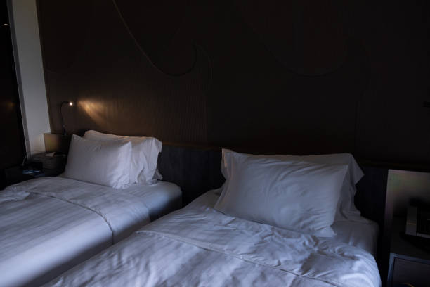 istock Close up white bedding sheets and pillow in hotel room 1334093900