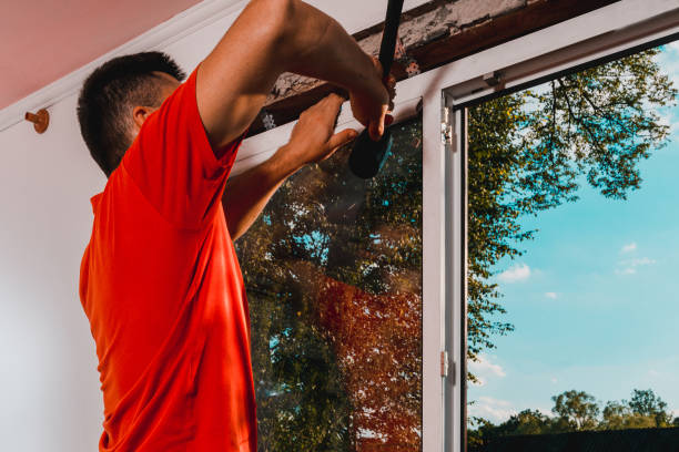 istock Window installation, a new plastic window in a private house, the master uses a rubber hammer to install the window. 1334097009