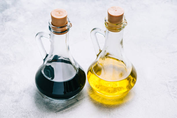 оливковое масло и бальзамический уксус в бутылках на столе. салатный соус - balsamic vinegar olive oil bottle cooking oil стоковые фото и изображения