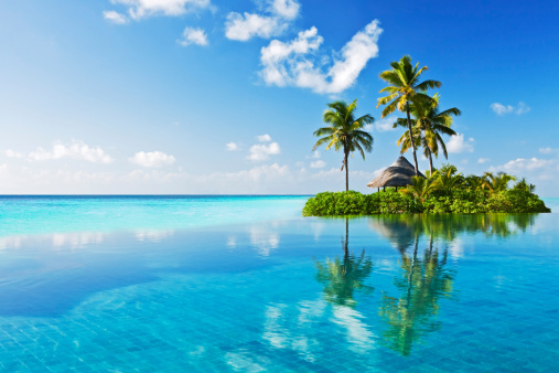 View of woman swinging on white sand beach relaxing and sunbathing by the lagoon in Mexico