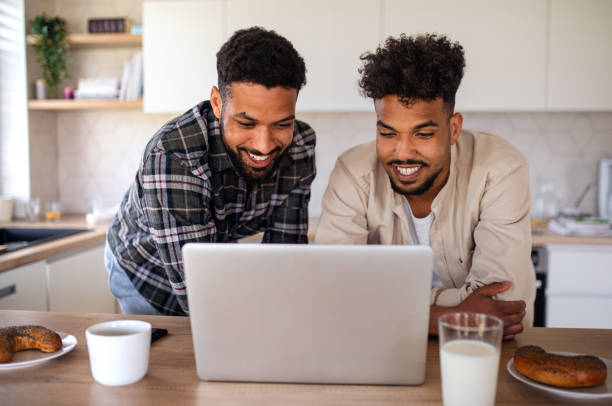 istock Young student brothers in kitchen indoors at home, using laptop. 1334099006