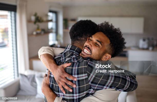 Young Happy Adult Brothers In Kitchen Indoors At Home Hugging Stock Photo - Download Image Now