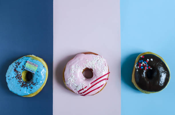 istock Donuts with icing on a colored background. Sweet donuts on a three-color background close-up 1334100218