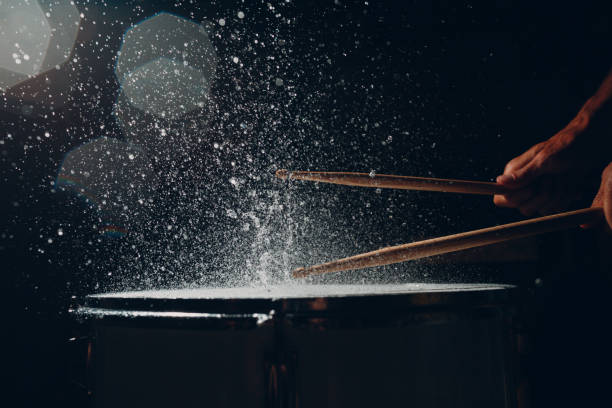 istock Drum sticks drumming beat rhythm on drum surface with splash water drops 1334102061