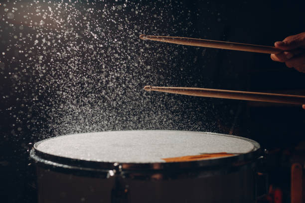 istock Drum sticks drumming beat rhythm on drum surface with splash water drops 1334102068