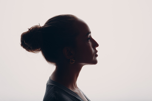 Adult young woman silhouette portrait in studio.