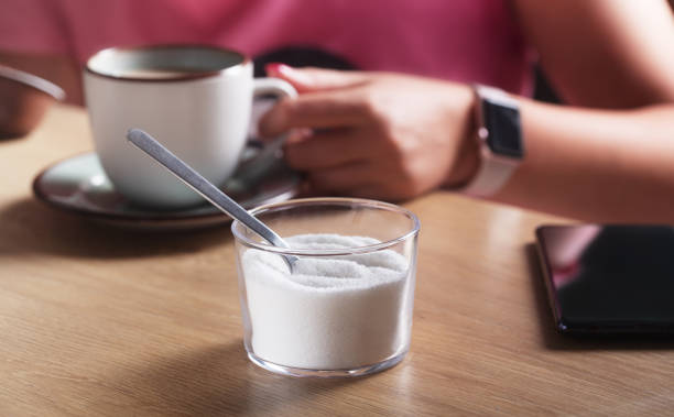 mulher segurando uma xícara de café com leite e ao lado do adoçante - sweetening - fotografias e filmes do acervo