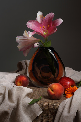 Studio still life with flowers lilies and fruits in vintage style