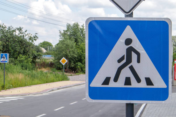 istock Pedestrian overground crossing, old square white with blue reflective road sign, outdoors close-up. Zebra and human sign on the background of the city. Pedestrian crossing sign 1334104747