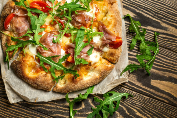 istock Prosciutto pizza with  strachatella cheese on woods 1334105083