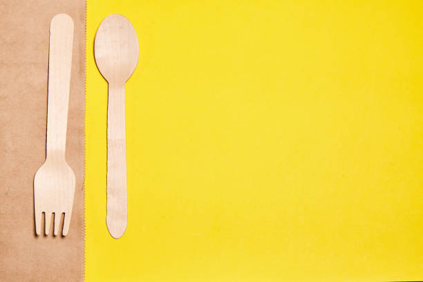 istock Eco-friendly disposable tableware made of bamboo wood and paper. Disposable tableware from natural materials, wooden spoon, fork, eco-friendly. Place for text. Layout of wooden disposable teaspoons 1334109396