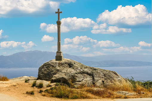 Stone cross on a cliff on the coast of Finisterre in Galicia Spain.
