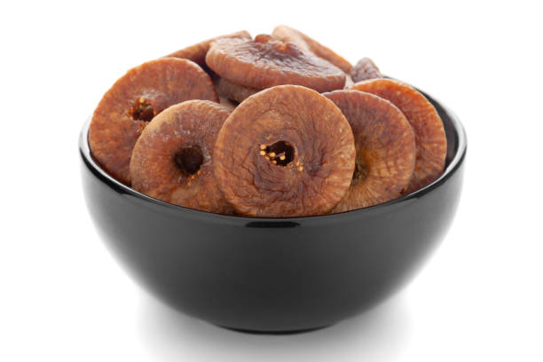 Close-up Organic dry fruit fig  (Ficus carica)  in black ceramic  bowl on white background