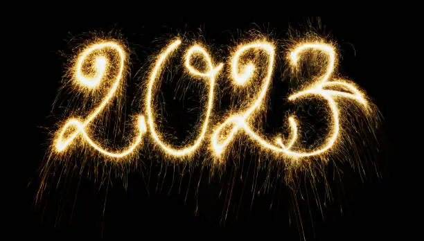 Sparkling  Year 2023 painted with sparkles. Written on a deep black background.