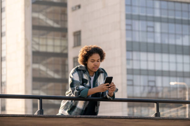 istock Female teenager scrolling in smartphone while bending over railings 1334116059