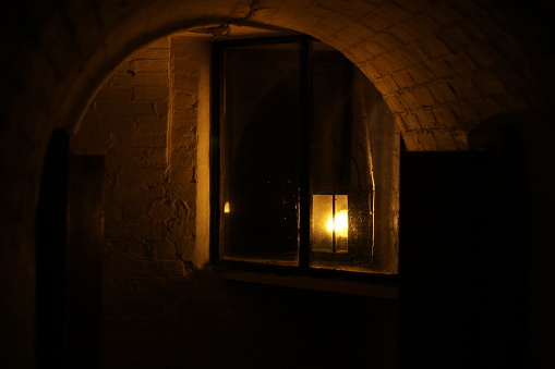 A dimly lit alleyway lit by one lamp dark victorian London looking