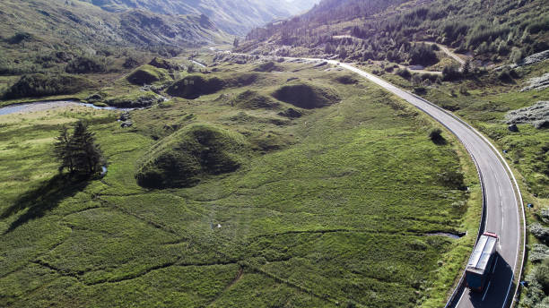 грузовик едет через глен шил, шотландское нагорье - travel scotland forest field стоковые фото и изображения