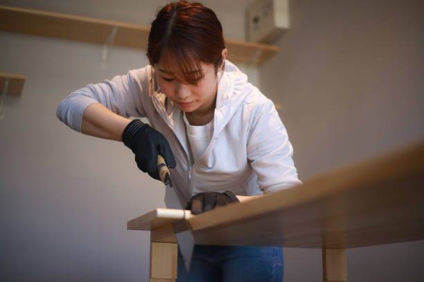 istock DIY image of a woman cutting a tree with a saw 1334124294