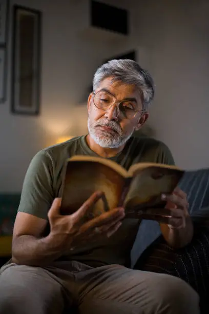 Man reading a book on sofa at home
